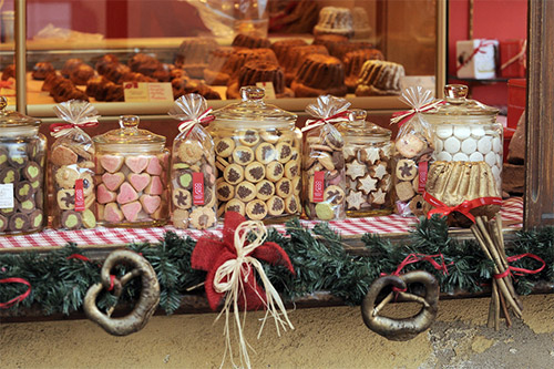 Puestos de especialidades alsacianas en un mercado navideño tradicional con fachadas de entramado