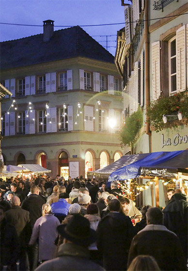 Traditioneller Weihnachtsmarkt im Elsass mit beleuchteten Hütten und festlicher Dekoration