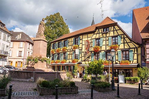 Kopfsteinpflastergasse mit typischen Fachwerkhäusern in einem elsässischen Dorf im Herbst