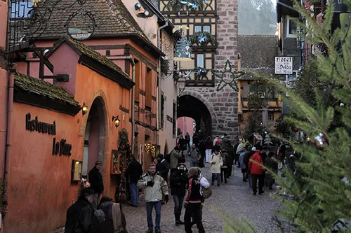 Illuminated Alsatian Christmas market at night with fairy lights and magical atmosphere